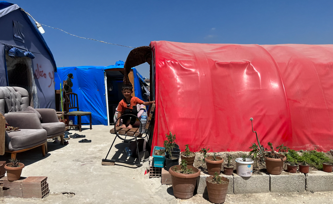 Boy outside tent in refugee camp